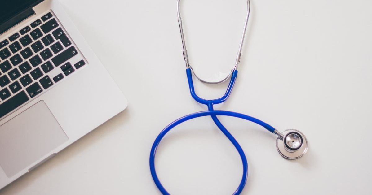 Estetoscópio azul ao lado de um notebook, ilustrando a perícia médica do INSS